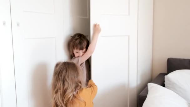 Little brother and sister in casual clothing hide in closet — Video Stock