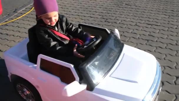 Geïnteresseerd meisje in jas en hoed rijdt automatische auto — Stockvideo