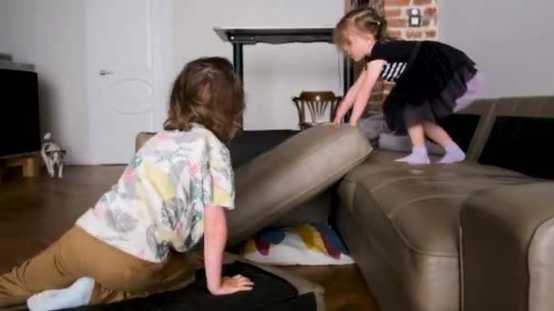 Malé děti předškoláci chlapec a dívka hrát s pohovkou polštáře — Stock video