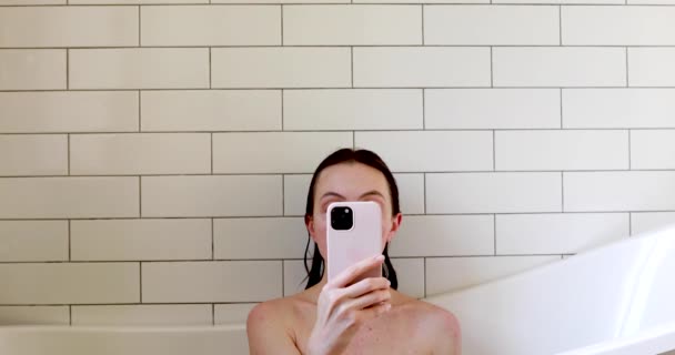 Mujer usando smartphone en bañera — Vídeo de stock