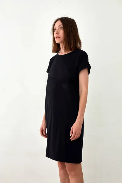 Взрослая женщина в обычном черном платье белом фоне — стоковое фото