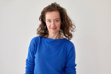 Mavi örgü süveter giyen gülümseyen kadın beyaz arka plan