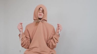 Yüzünde büyük bir doğum lekesi olan üzgün genç kız kapüşonunda saklanıyor.