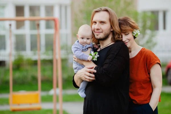 Família feliz com bebê no playground ao ar livre — Fotografia de Stock