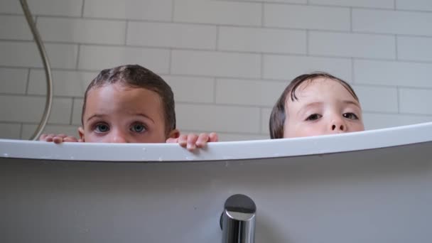 A kishúgom és a bátyám otthon ülnek a kényelmes fürdőkádban. — Stock videók