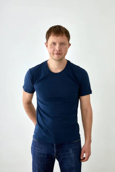 Pozitivní mladý muž v ležérní oblečení stojící na bílém pozadí — Stock fotografie