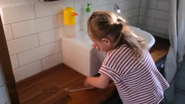 Joven niña preescolar con cabello claro lava soporte de madera — Vídeo de stock
