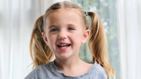 Graciosa niña sonriendo mirando a la cámara en casa — Foto de Stock