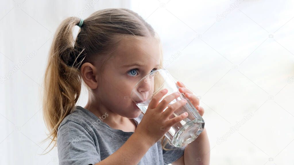 Child girl drinks water silhouette window background