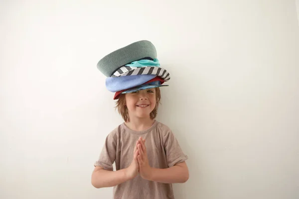 Förtjusande liten pojke i olika hattar på huvudet — Stockfoto