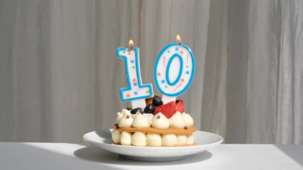 Svíčkový dort deset na stole proti slunečnímu svitu — Stock video
