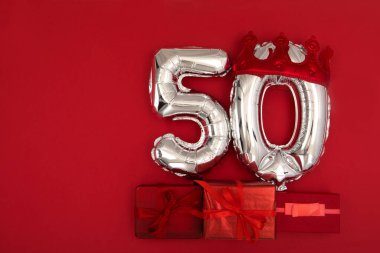 Koyu kırmızı arka planda 50 numaralı balon yatıyordu.