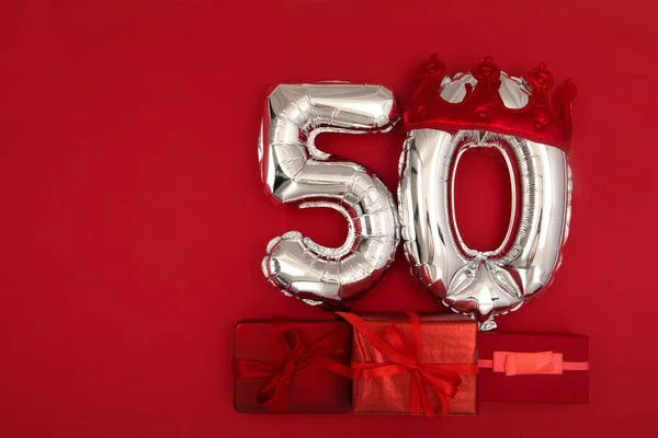 Ballon 50 in kroon op donkerrode achtergrond plat lay — Stockfoto