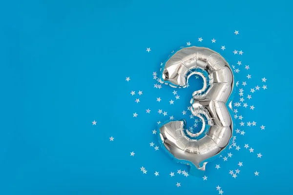 Silver balloon 3 on a blue background with confetti stars — Stock Photo, Image