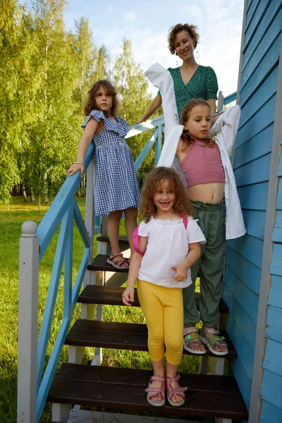 Mother with daughters standing outside house countryside — Stock Photo, Image