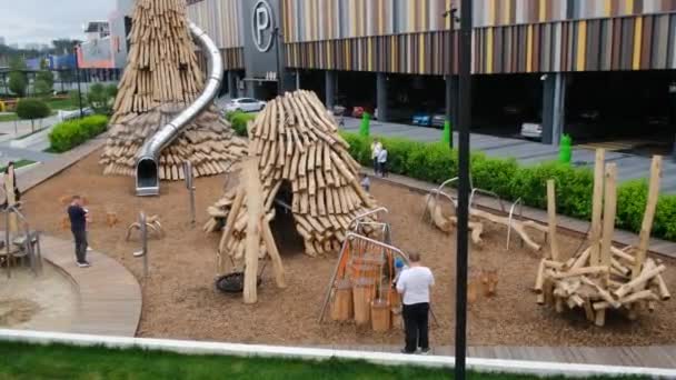 Ekaterinbourg, Russie-26 juillet 2021 : Les pères marchent avec les enfants sur une aire de jeux de matériaux écologiques — Video