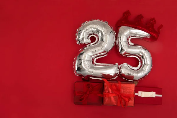 Fólia Ezüst Léggömbök Száma Huszonöt Helyezett Piros Háttér Csomagolt Ajándékokkal — Stock Fotó