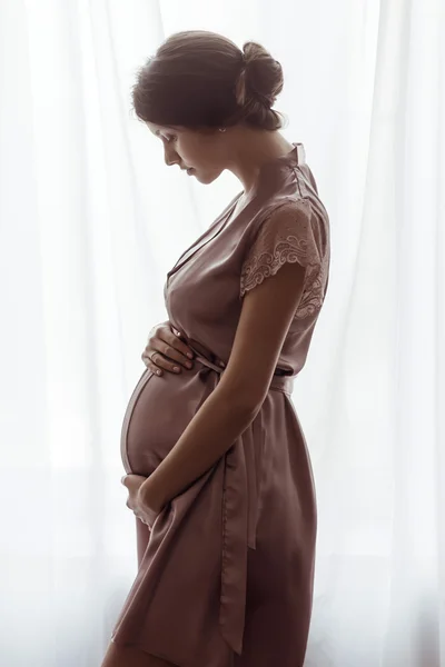 Silhouette of pregnant woman,  window — Stock Photo, Image