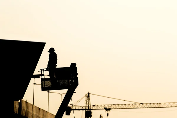 Silhouette eines Bauarbeiters auf einem Gerüst in der Konstruktion — Stockfoto