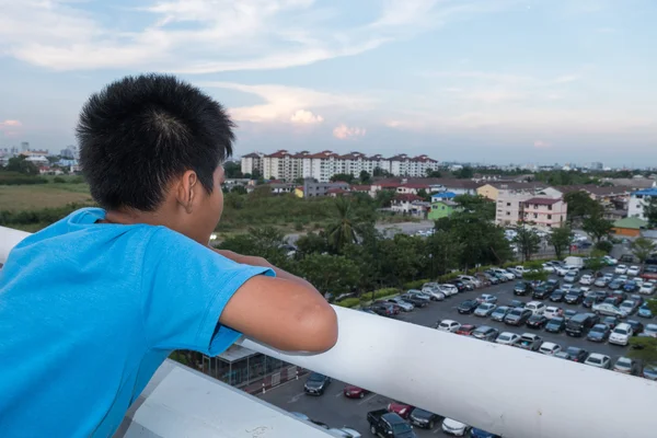 Gyermek egy felhőkarcoló tetején állt, és megfigyeljük a város — Stock Fotó