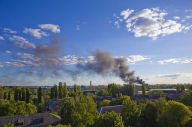Mavi gökyüzünün önündeki ateşten siyah duman
