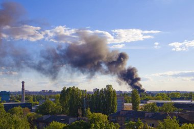 Mavi gökyüzünün önündeki ateşten siyah duman