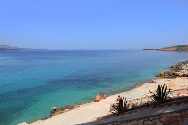 Arnavutluk 'un Ksamil kentindeki İyon Denizi' nin masmavi sularıyla dolu plaj