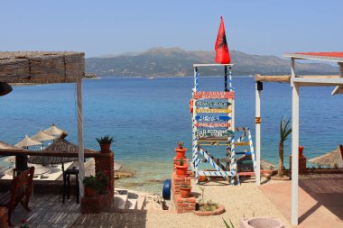 Arnavutluk 'un Ksamil kentindeki İyon Denizi' nin masmavi suyuyla sahile giden yol