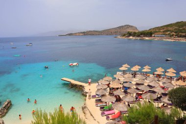 Arnavutluk 'un Ksamil kentindeki İyon Denizi' nin masmavi sularıyla dolu plaj