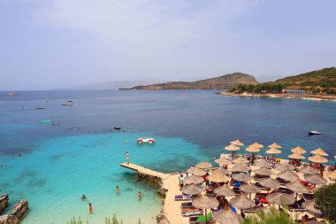 Arnavutluk 'un Ksamil kentindeki İyon Denizi' nin masmavi sularıyla dolu plaj