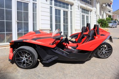 Saranda, Arnavutluk - 3 Temmuz 2021. Saranda caddesinde alışılmadık kırmızı üç tekerlekli bir araba.