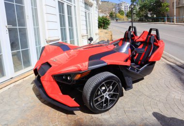 Saranda, Arnavutluk - 3 Temmuz 2021. Saranda caddesinde alışılmadık kırmızı üç tekerlekli bir araba.