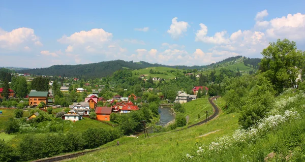 Landskap i Vorohta med bergen, floden och järnvägen, Ukraina Stockbild