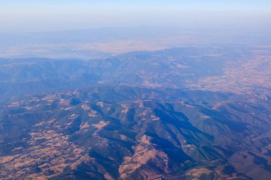Sardunya Adası 'nın (İtalya) en tepedeki manzarası güneşli bir günde bir uçaktan bulutların üzerinde