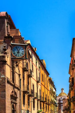 Bosa, Sardunya, İtalya 'da tipik işlenmiş demir balkonları ve antika duvar saatleri olan bir ev.