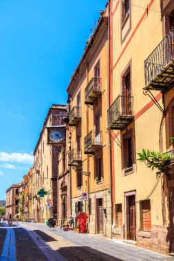 Bosa, Sardunya, İtalya 'da tipik işlenmiş demir balkonları ve antika duvar saatleri olan bir ev.