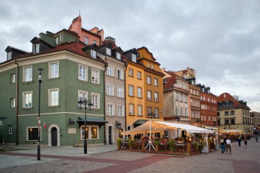 Polonya 'nın Eski Varşova şehrinde Castle Square ve sokak kafelerindeki renkli evler