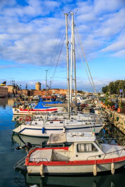 İtalya 'nın Livorno şehrinde güneşli bir günde Ampolletta Havzası yakınlarındaki eski limanda tahta tekne ve yatlar.