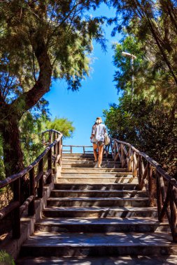 Kız Yunanistan 'ın Girit kentindeki Chania' da kozalaklı bir ormana çıkan tahta merdivenlere tırmanıyor.