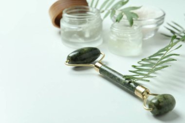 Beyaz arka planda yüz silindirli cilt bakımı kavramı