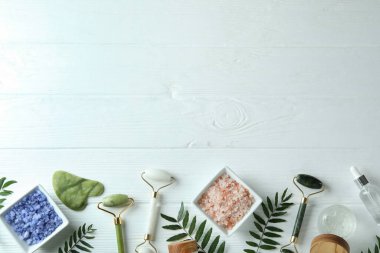 Beyaz ahşap arka planda yüz silindirli cilt bakımı kavramı