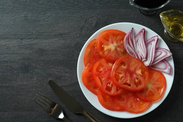 暗いテーブルの上にトマトカルパッチョとおいしい料理の概念 — ストック写真