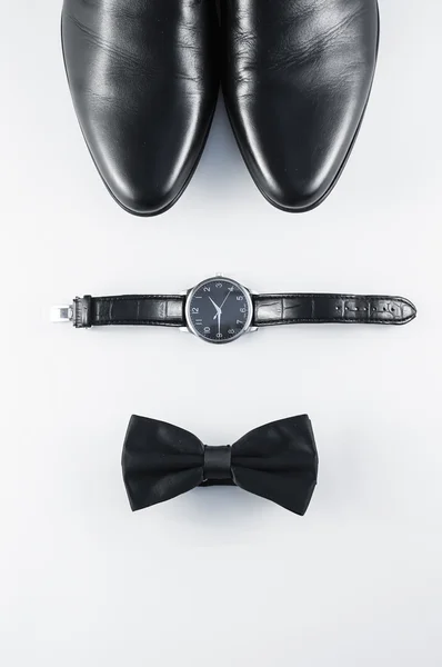 Composición minimalista en blanco y negro: zapatos de hombre, relojes y pajarita sobre fondo blanco . — Foto de Stock