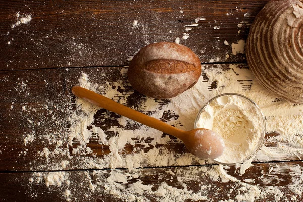 Pão e farinha na mesa — Fotografia de Stock