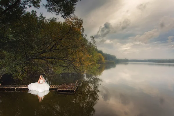 Noiva sentado perto do lago — Fotografia de Stock