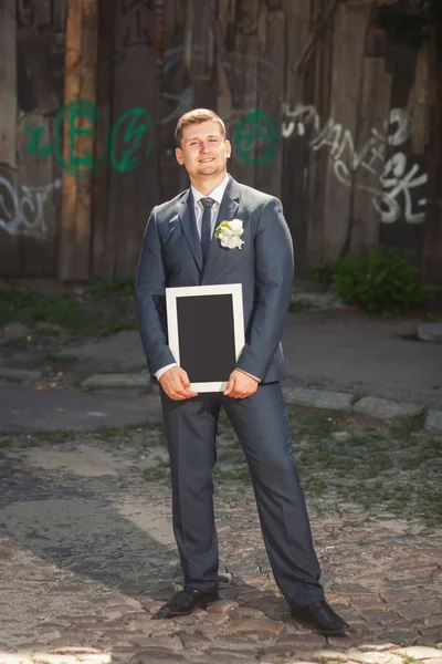 Bräutigam mit leerem Plakat — Stockfoto