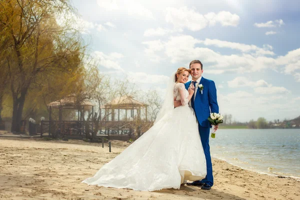 Bride and groom near river — Stock Photo, Image