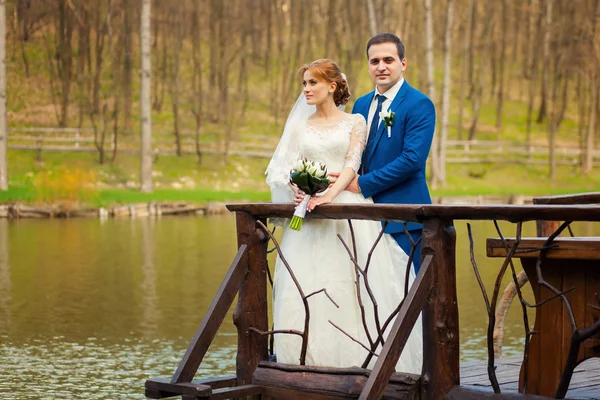 Bride and groom near big lake — Stock Photo, Image