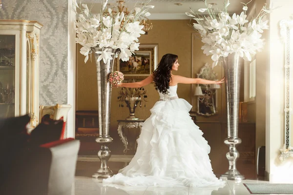 Noiva em vestido de noiva branco com flores grandes — Fotografia de Stock