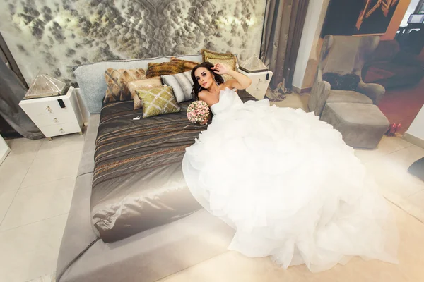 Yatakta beyaz gelinlik içinde gelin. Üstten Görünüm